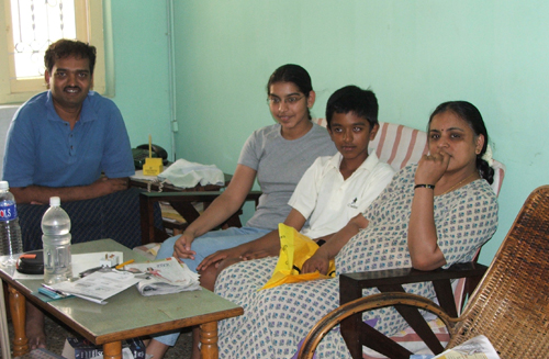 Ravi seated at a dining table with family.